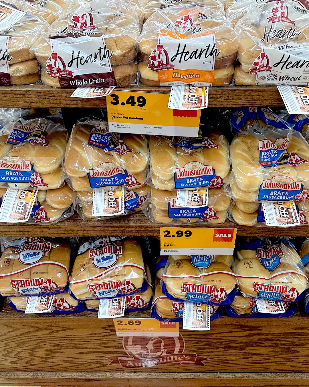 Bun packages with coupons on a store rack.